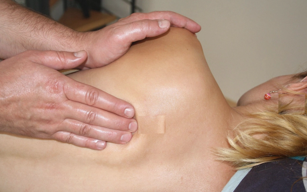 Heated basalt stones resting along a client's spine during a ritual